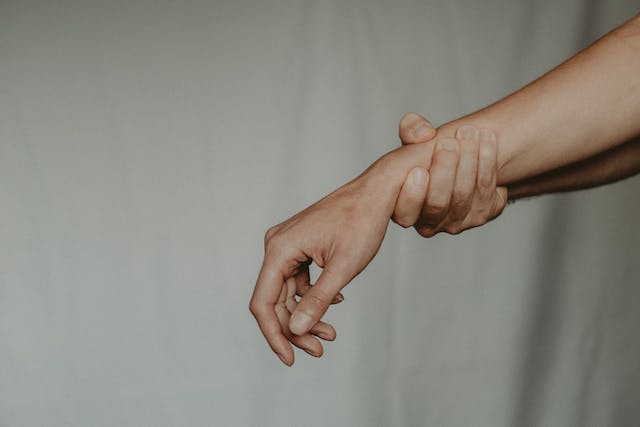 One hand grasping a person's wrist to support them
